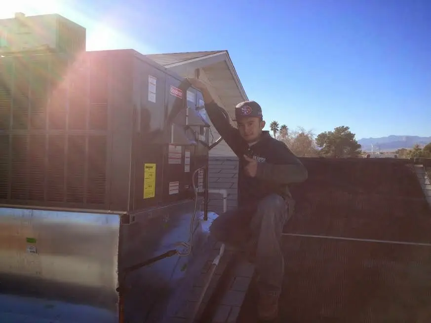 HVAC technician performing Heat Pump Repair on a rooftop unit in Palmyra